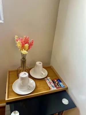 a table with two plates and a vase with flowers at L and D Homestay in Manila