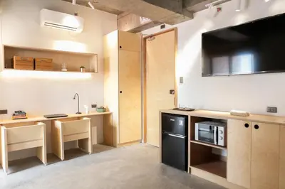 a kitchen with a large tv on the wall at HomeBase Apartment Hotel in Manila