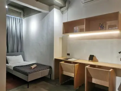a small room with a bed and a desk at HomeBase Apartment Hotel in Manila