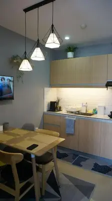 a kitchen with a wooden table and a kitchen with a counter at THE FIKA ROOM near MNL Airport - Scandi Studio Unit with Fast Wi-Fi & Netflix - Read Full Property Desc before booking in Manila
