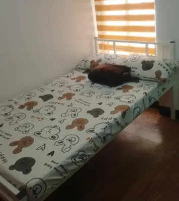 a dog sleeping on a bed in a bedroom at KS RESIDENCES in Manila