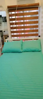 a bed with two blue pillows in a room at KS RESIDENCES in Manila