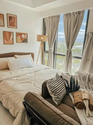 a bedroom with a large bed with a large window at Chic and Cozy Studio Viceroy Residences Taguig in Manila
