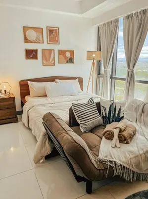 a large bed in a bedroom with a window at Chic and Cozy Studio Viceroy Residences Taguig in Manila