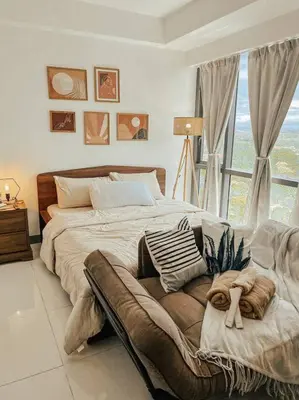 a large bed in a bedroom with a window at Chic and Cozy Studio Viceroy Residences Taguig in Manila
