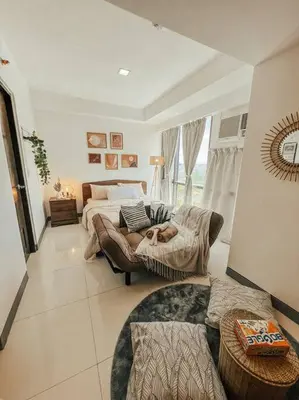 a large bedroom with a bed and a couch at Chic and Cozy Studio Viceroy Residences Taguig in Manila