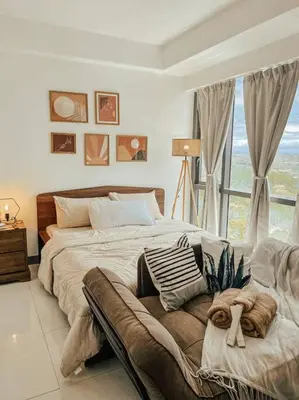 a bedroom with a large bed and a large window at Chic and Cozy Studio Viceroy Residences Taguig in Manila