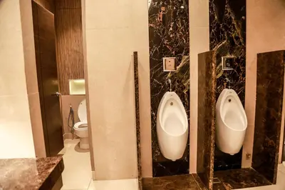 a bathroom with two urinals and a toilet at Sotogrande Hotel Katipunan in Manila