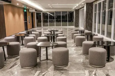 a lobby with tables and stools in a building at Sotogrande Hotel Katipunan in Manila