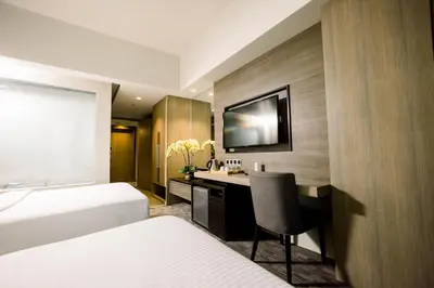 a hotel room with two beds and a desk at Sotogrande Hotel Katipunan in Manila