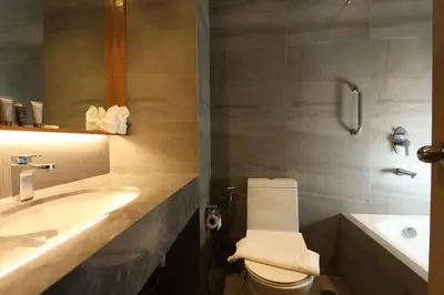 a bathroom with a sink and a toilet and a tub at Sotogrande Hotel Katipunan in Manila