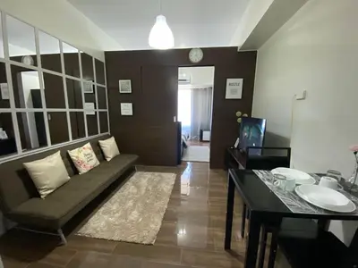 a living room with a couch and a table at Air Residences 1-Bedroom condo in Makati in Manila