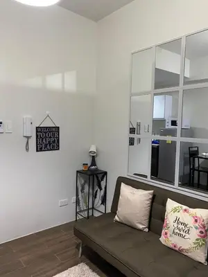 a living room with a couch and a large window at Air Residences 1-Bedroom condo in Makati in Manila