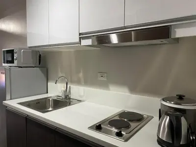 a kitchen with a sink and a stove top oven at Air Residences 1-Bedroom condo in Makati in Manila