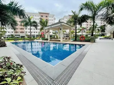 a swimming pool with a gazebo next to a building at Cozy Belle Suite Relaxing Place at SMDC Hope Residences in Trece Martires