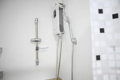 a shower in a bathroom with a shower head at Cozy Belle Suite Relaxing Place at SMDC Hope Residences in Trece Martires