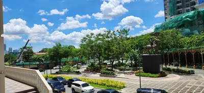 a parking lot with parked cars and a statue at Casa Antonio At Uptown Parksuites Two in Manila