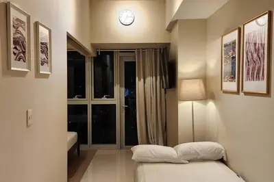 a bedroom with a bed and a clock on the wall at Casa Antonio At Uptown Parksuites Two in Manila