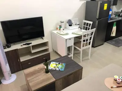 a living room with a flat screen tv and a table at Kasara Urban Resort and Residences in Manila