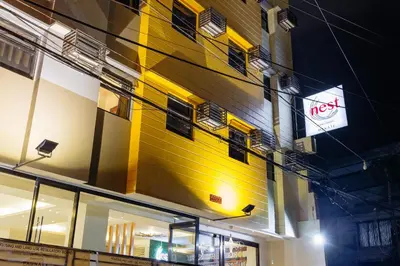 a yellow building with a sign in front of it at Nest Nano Suites Poblacion - Makati in Manila