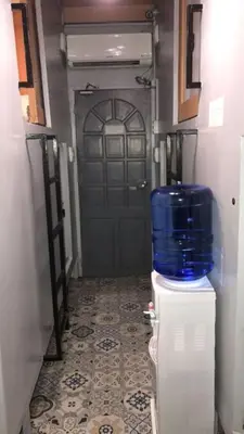 a door with a blue barrel on top of a refrigerator at Budget Transient Capsule Room Makati near Ayala and Buendia in Manila
