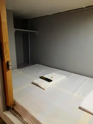 a bed with a cell phone sitting on top of it at Budget Transient Capsule Room Makati near Ayala and Buendia in Manila