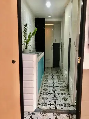 a corridor of a bathroom with a tile floor at Budget Transient Capsule Room Makati near Ayala and Buendia in Manila