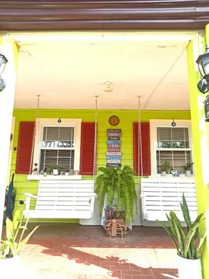 a yellow house with red and white shutters at Madie's Place Guest House in Santa Rosa
