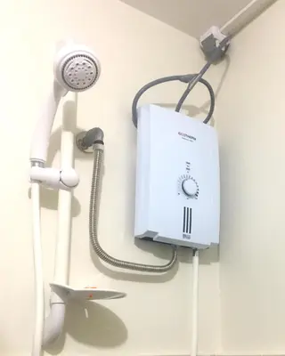 a white appliance hanging on a wall next to a shower at Madie's Place Guest House in Santa Rosa