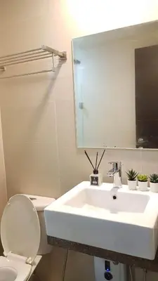 a bathroom with a sink and a toilet and a mirror at 101 Newport blvd C2 4F by Rechelle Nunag in Manila