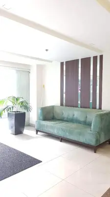 a green couch in a living room with a plant at 101 Newport blvd C2 4F by Rechelle Nunag in Manila