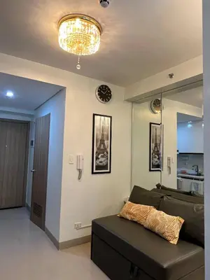 a living room with a couch and a chandelier at Overnight @ Shakhbot's in Manila