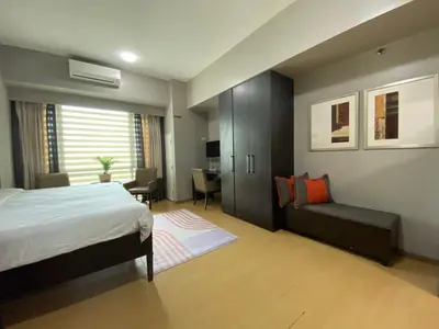 a bedroom with a bed and a couch and a desk at Avant at the Fort by Urban Realty in Manila