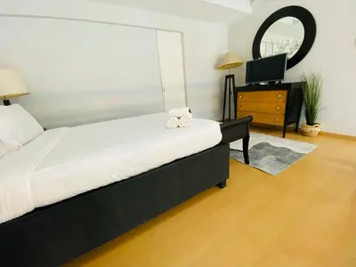 a bedroom with a large bed and a television at Avant at the Fort by Urban Realty in Manila