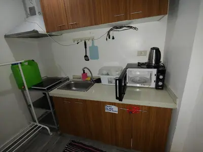 a small kitchen with a sink and a microwave at ADB Avenue Tower Ortigas Manila in Manila