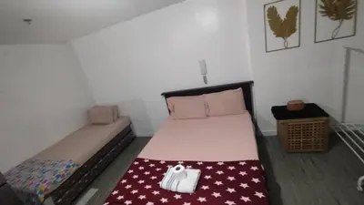 a small bedroom with a bed with a purse on it at ADB Avenue Tower Ortigas Manila in Manila
