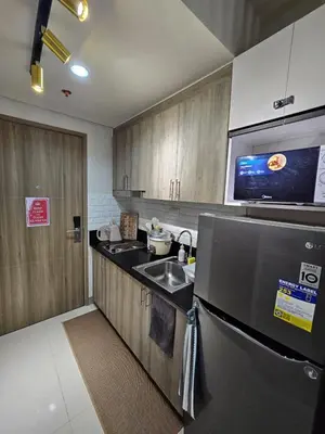 a kitchen with a sink and a refrigerator at S Residences Tower 3 MOA Luxe Staycation by C in Manila