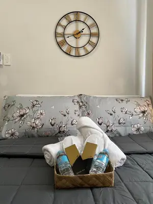 a basket of books and a clock on a couch at S Residences Tower 3 MOA Luxe Staycation by C in Manila