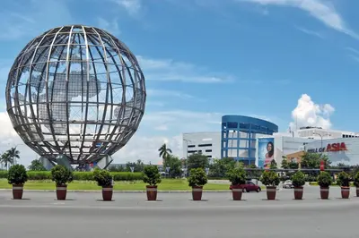 a large metal sphere and potted plants in front of a building at S Residences Tower 3 MOA Luxe Staycation by C in Manila