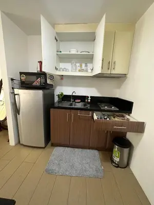 a small kitchen with a sink and a refrigerator at Cecillian place staycation @ pasay in Manila