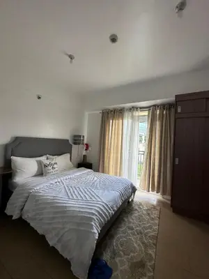 a bedroom with a large bed and a window at Cecillian place staycation @ pasay in Manila