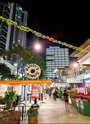 a city at night with people walking down a sidewalk at Uptown Parksuites BGC 1BR, Hi Flr Great view fr Balcony with Washer in Manila