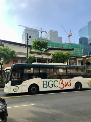 a bus is parked on the side of the street at Uptown Parksuites BGC 1BR, Hi Flr Great view fr Balcony with Washer in Manila