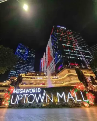 a lit up sign in front of two tall buildings at Uptown Parksuites BGC 1BR, Hi Flr Great view fr Balcony with Washer in Manila