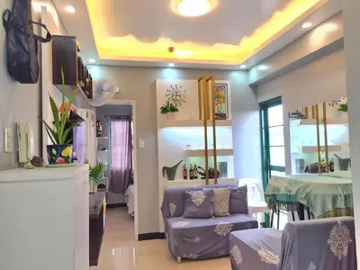 a living room with a purple couch and a table at Budget-friendly Transient Near Pasig/Mandaluyong in Cainta