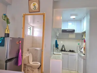 a small kitchen with a refrigerator and a toilet at Budget-friendly Transient Near Pasig/Mandaluyong in Cainta