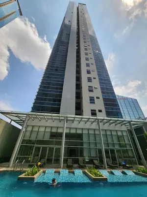 a tall building with a swimming pool in front of it at 20F Modern Cozy BGC Suite across 2 Major Malls with Washer FREE Parking in Manila