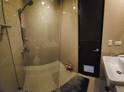 a bathroom with a glass shower and a sink at 20F Modern Cozy BGC Suite across 2 Major Malls with Washer FREE Parking in Manila