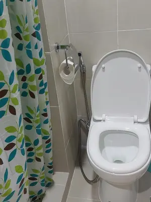 a bathroom with a toilet and a shower curtain at MOA staycation by Elsie D in Manila