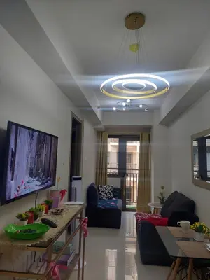 a living room with a ceiling with a chandelier at MOA staycation by Elsie D in Manila